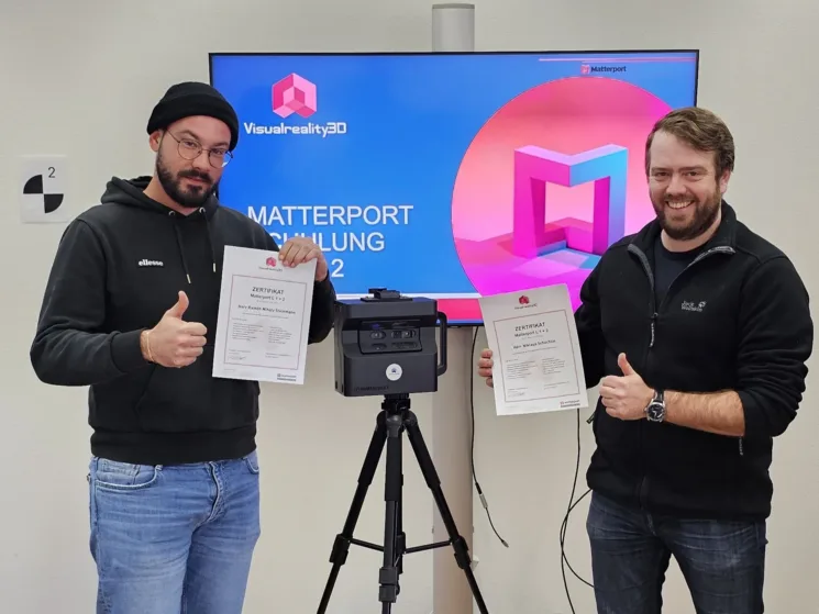 IMMO-ERBEN Team mit dem Zertifikat zur Matterport-Ausbildung. Die Kamera steht in der Mitte.